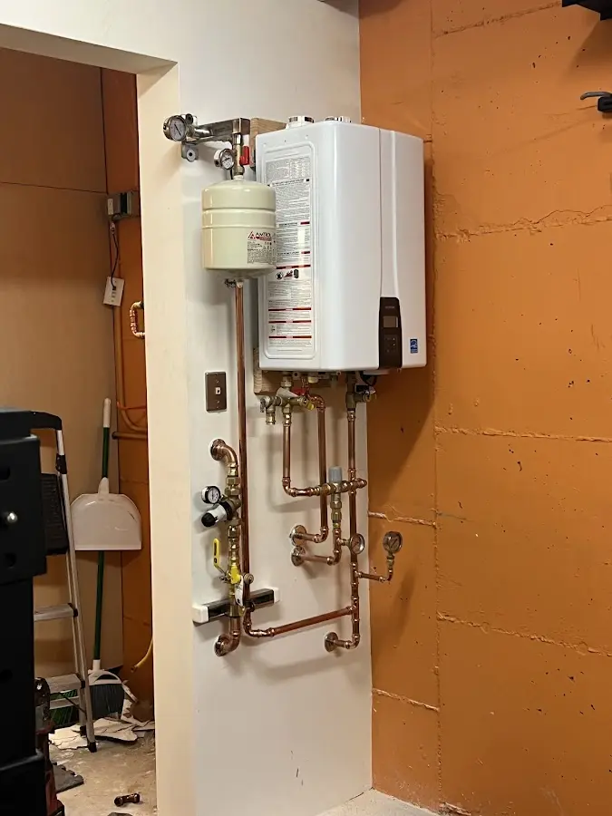 Plumbing technician inspecting water heater connections in Franklinton